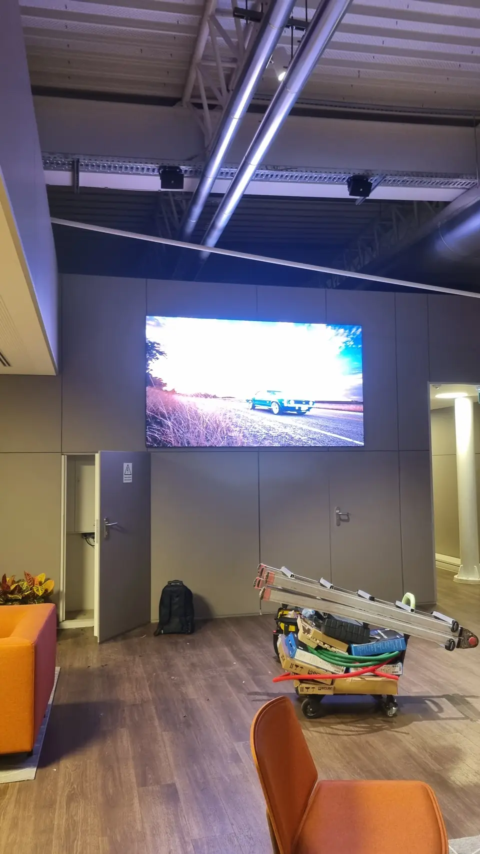 Ecrã LED na parede de uma zona lounge com cadeirões