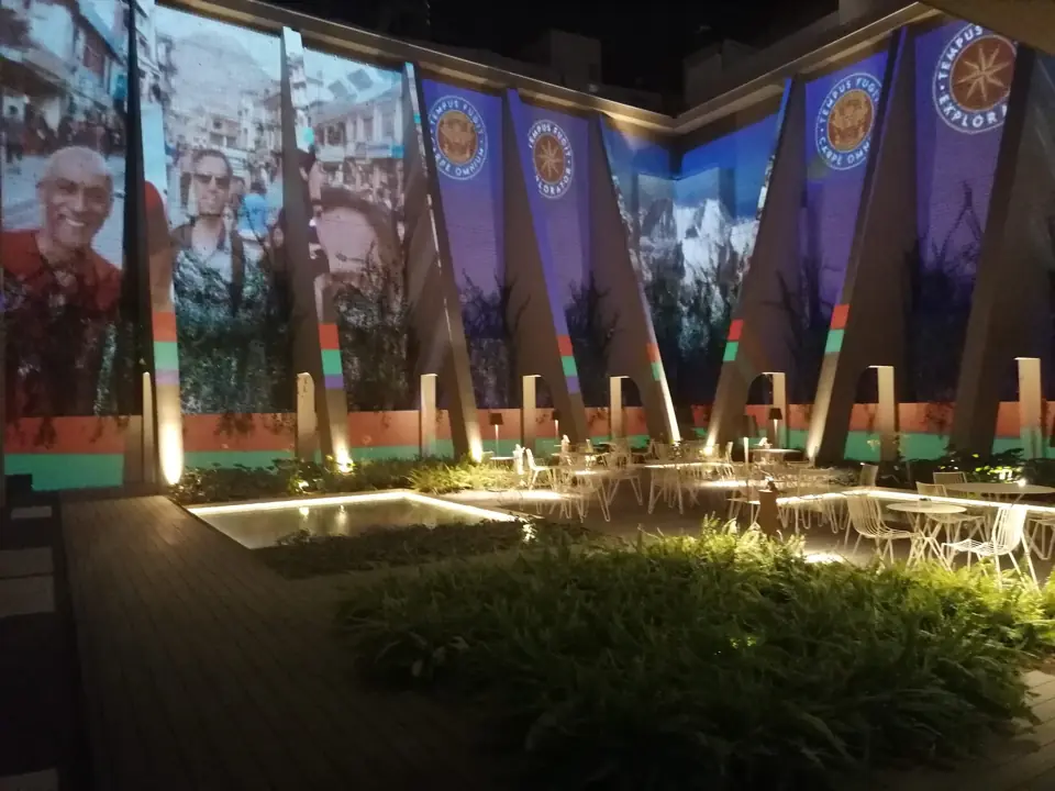 Pátio do hotel com projeções nas paredes e iluminação noturna