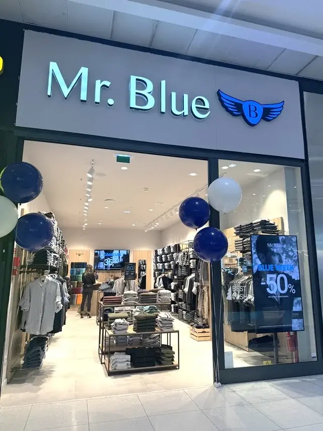 Fachada de loja Mr. Blue com ecrã de campanha na montra