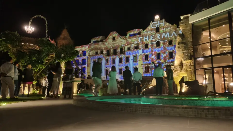 Fachada do GH Thermas iluminada com videomapping durante um evento noturno